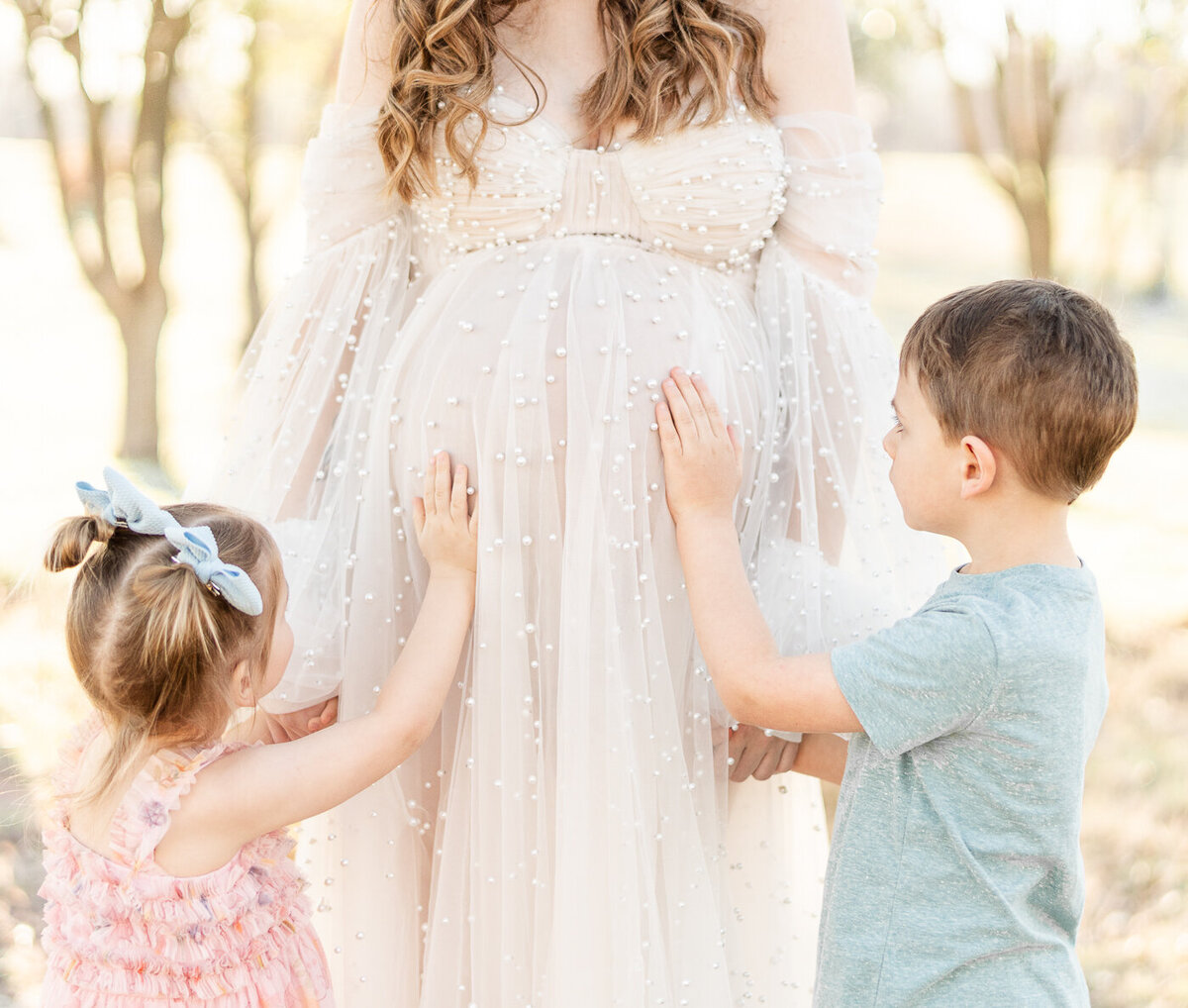 children touching moms baby bump