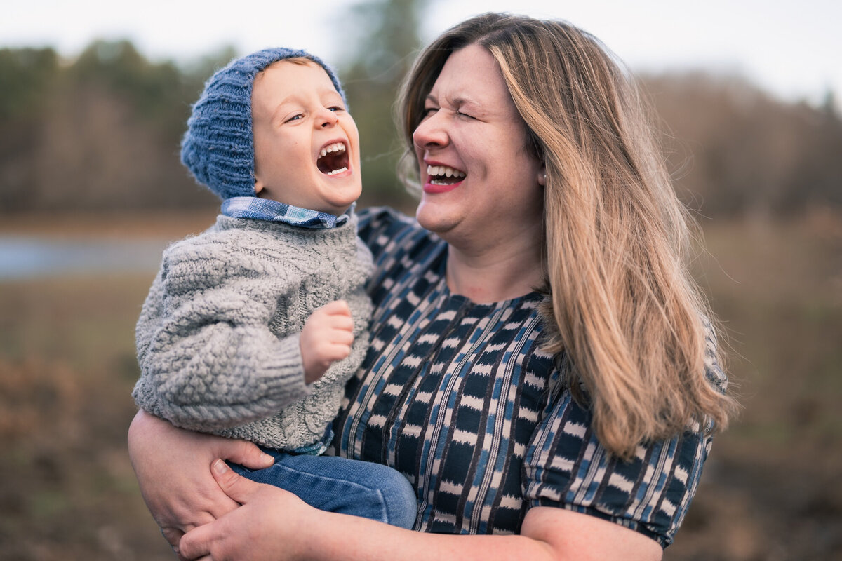 Mom and toddler laughing during family photo shoot near boston