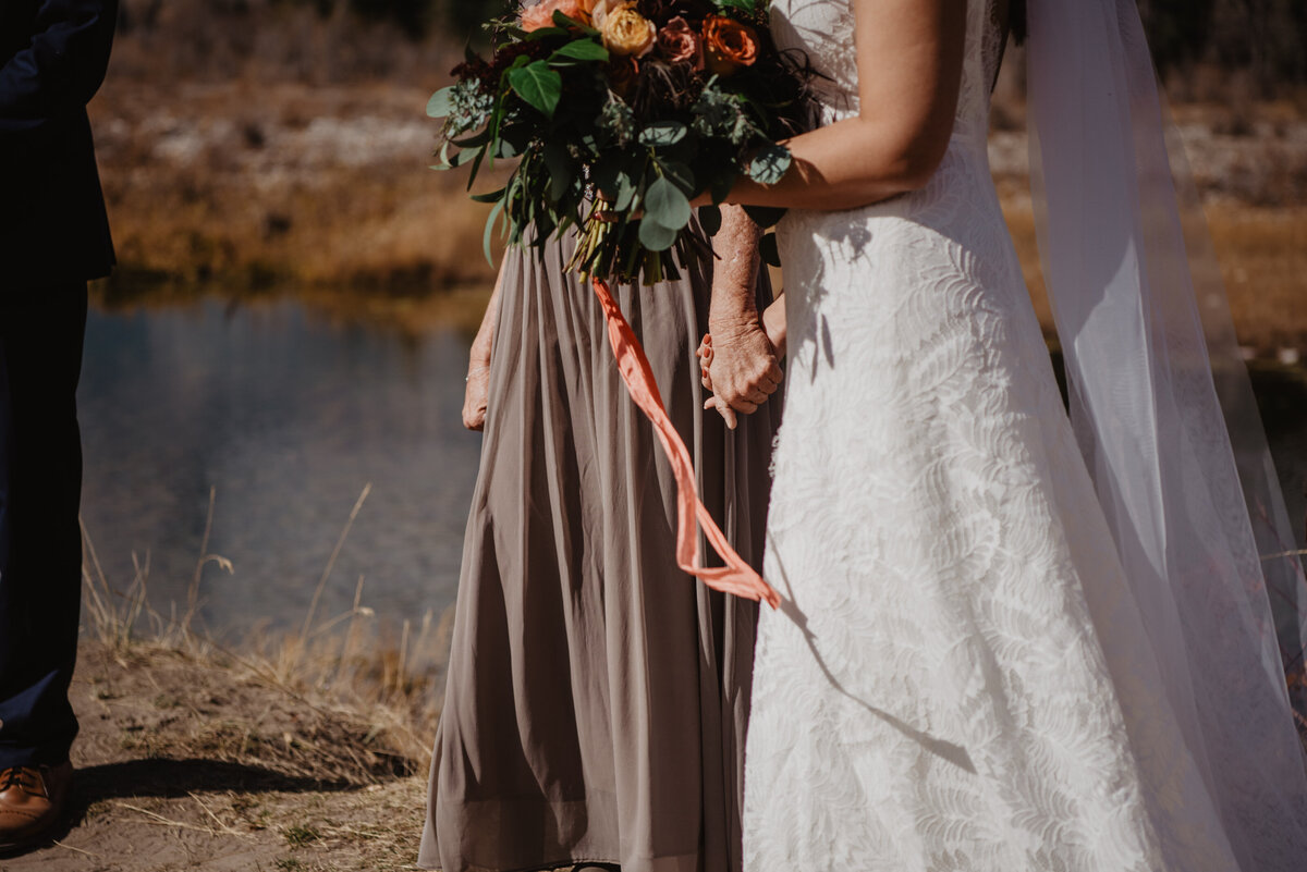 Photographers Jackson Hole capture bride walking holding bridal bouquet