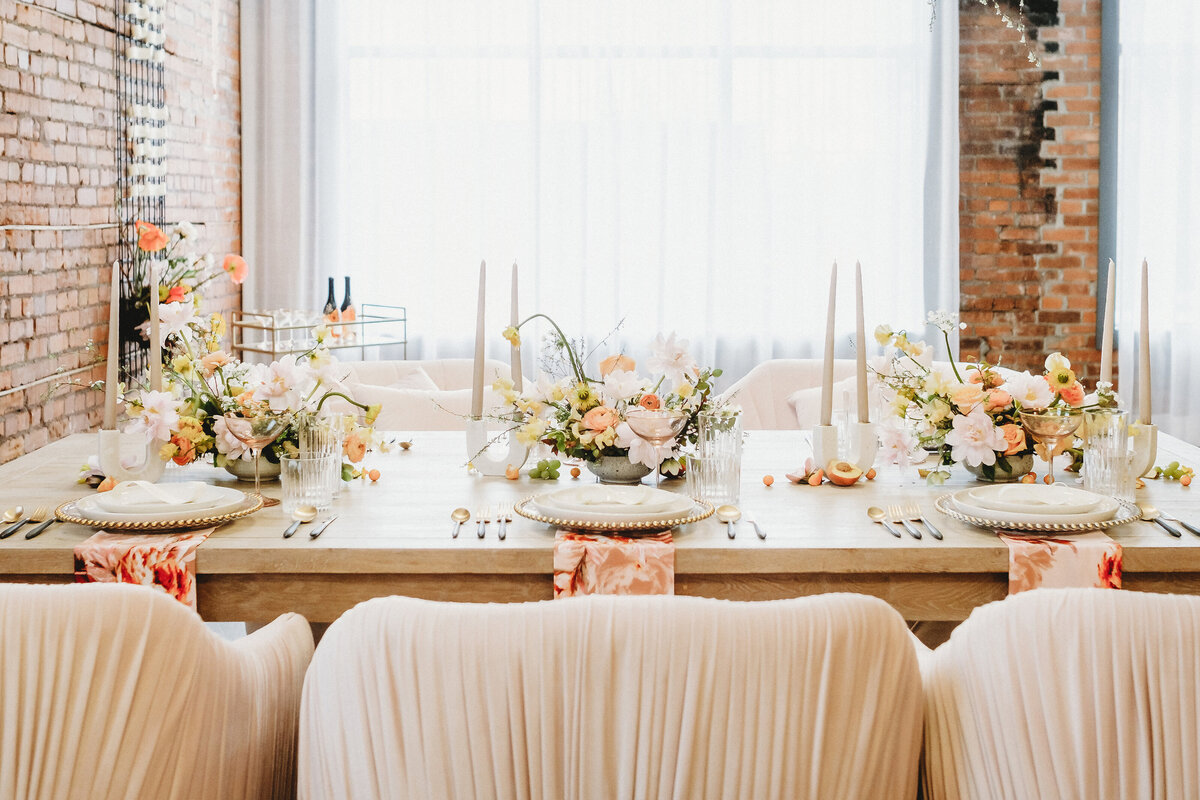 Peach, tangerine, and pink reception decor at Venue 308, a historical warehouse wedding venue in Calgary, featured on the Brontë Bride Vendor Guide.