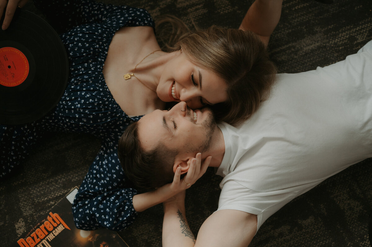 Couple laying face to face smiling photo taken at a record store Edmonton
