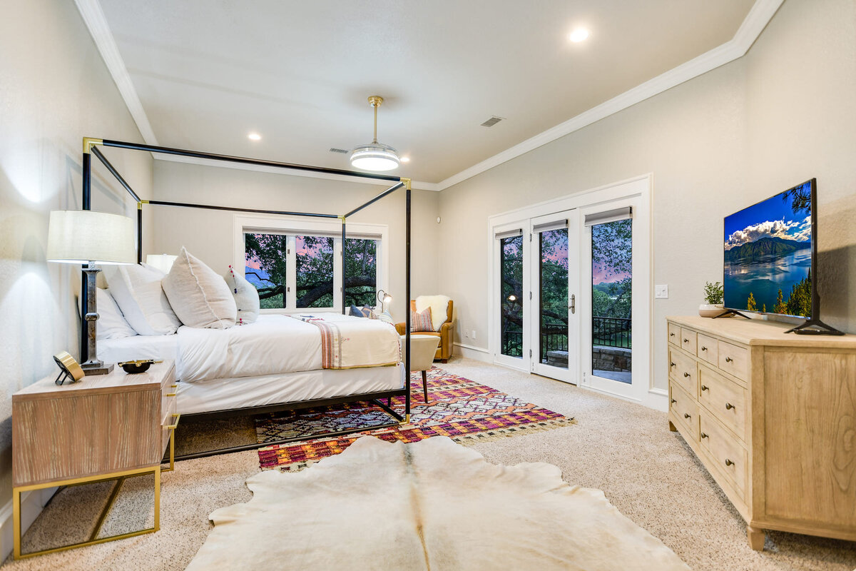 Master bedroom with 4 poster bed and a large window