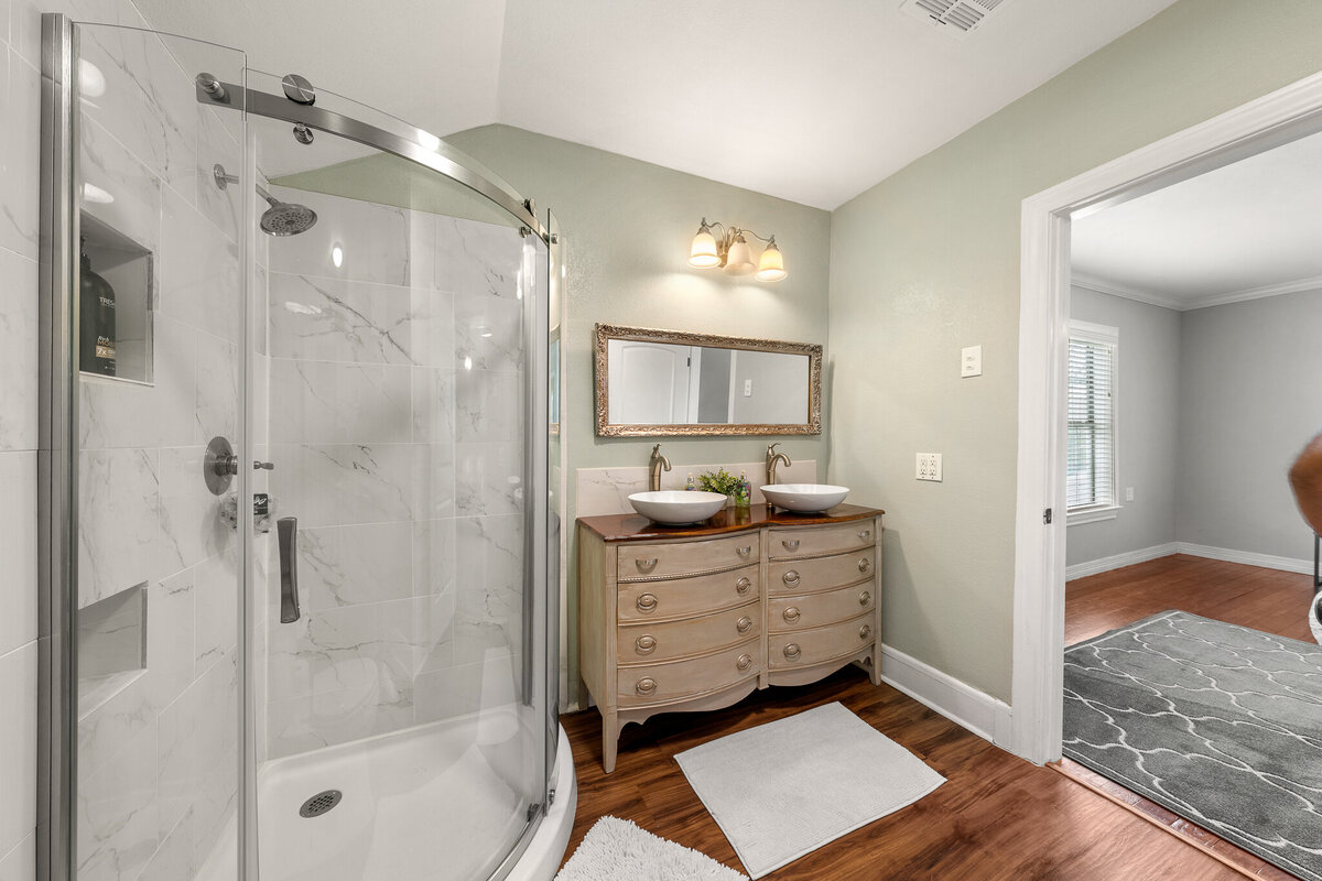 Bathroom with large shower and double vanity in this five-bedroom, 4-bathroom pet-friendly vacation rental house for 12 guests with free wifi, free parking, hot tub, mother-in-law suite, King beds and updated kitchen in downtown Waco, TX.