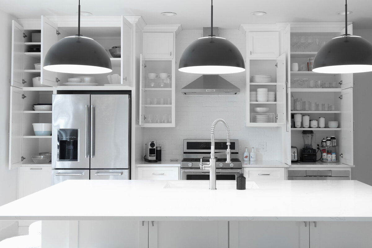 A kitchen with open cabinets revealing organized kitchenware