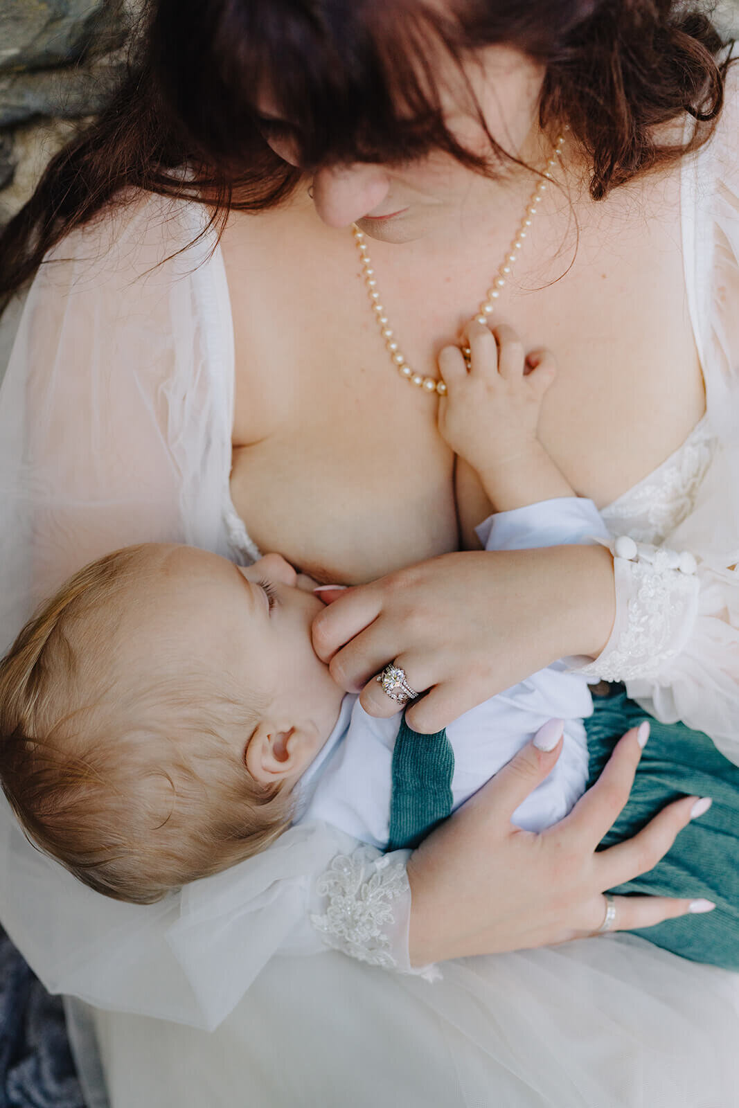 bride breastfeeding baby in her wedding dress