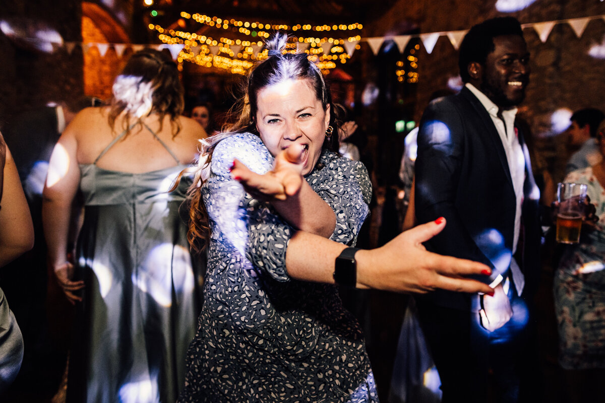 Wedding guest dancing at reception with disco lights