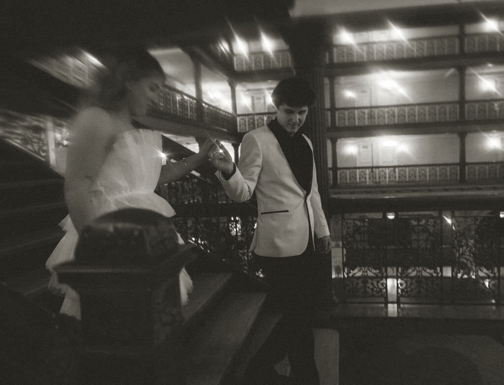 A wedding couple walking down a staircase.