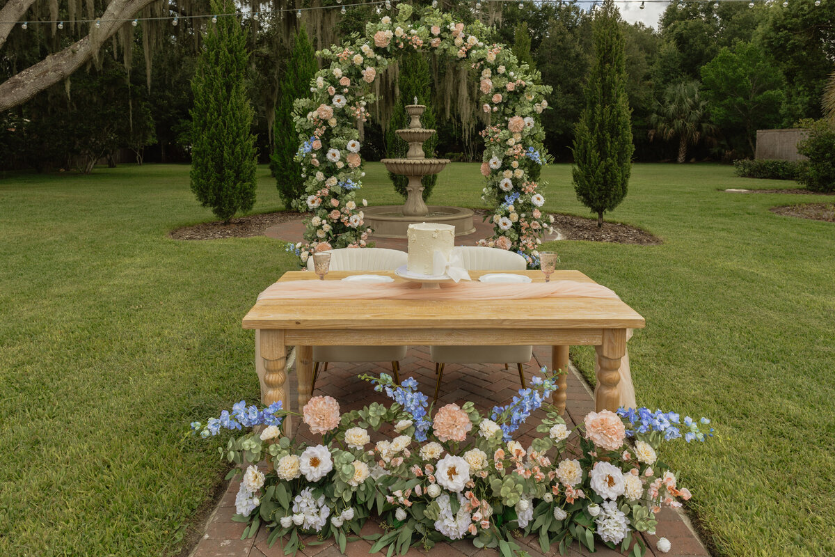Intimate Florida wedding ceremony in the backyard of The Palm Mansion with soft florals and palm tree views