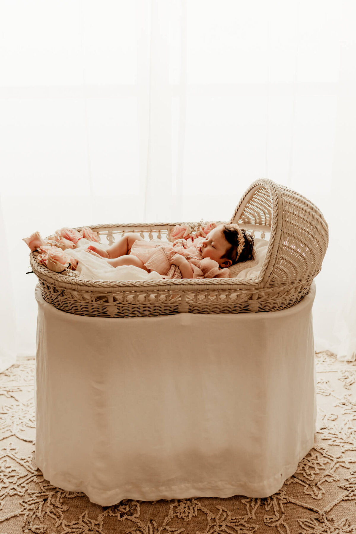 Baby girl sleeping in a white wicker bassinet in Oklahoma City.