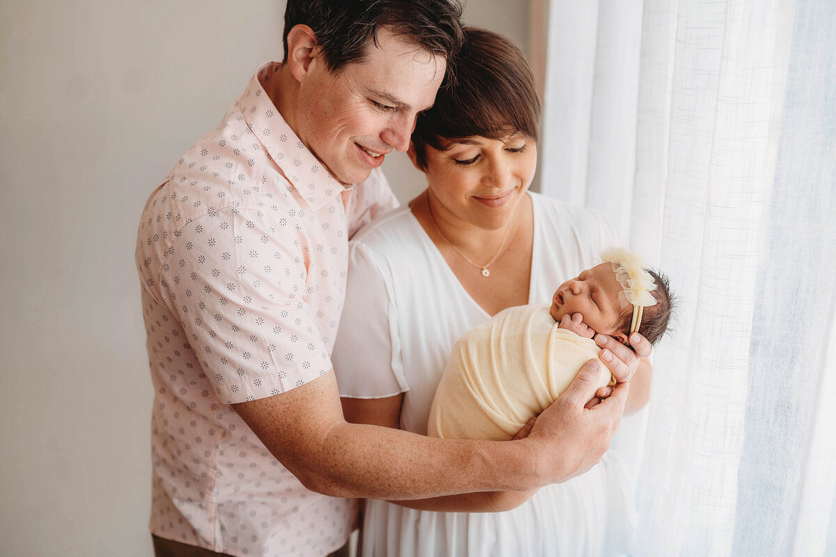 New parents gaze at their Newborn daughter during Newborn Photoshoot in Asheville.