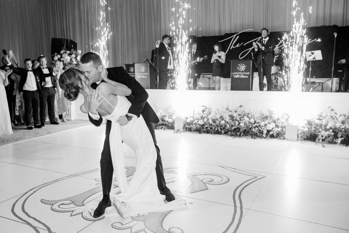 A magical first dance moment as the bride and groom share a kiss, surrounded by sparkling fireworks and live music.