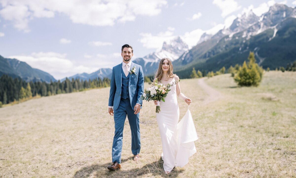 Couple walking acroos a meadow during thieir Calgary wedding day