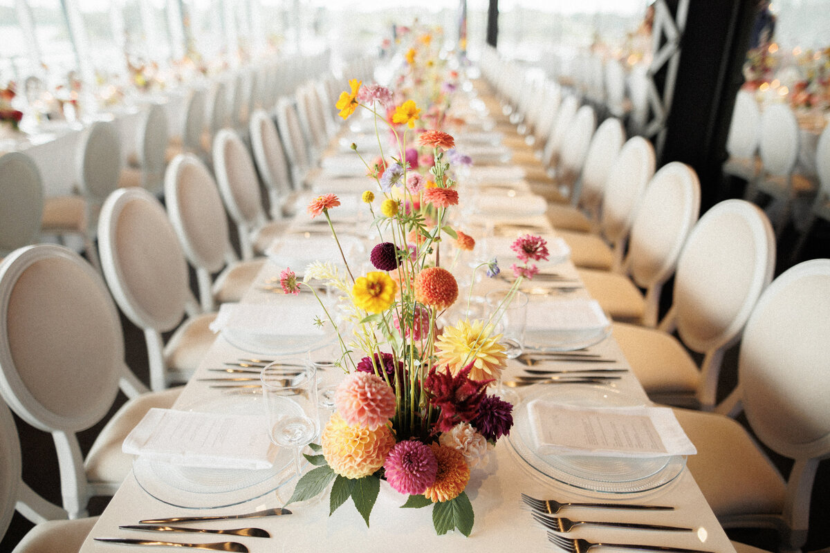 A table adorned with colourful, whimsical floral centrepieces at a Science Centre wedding reception.