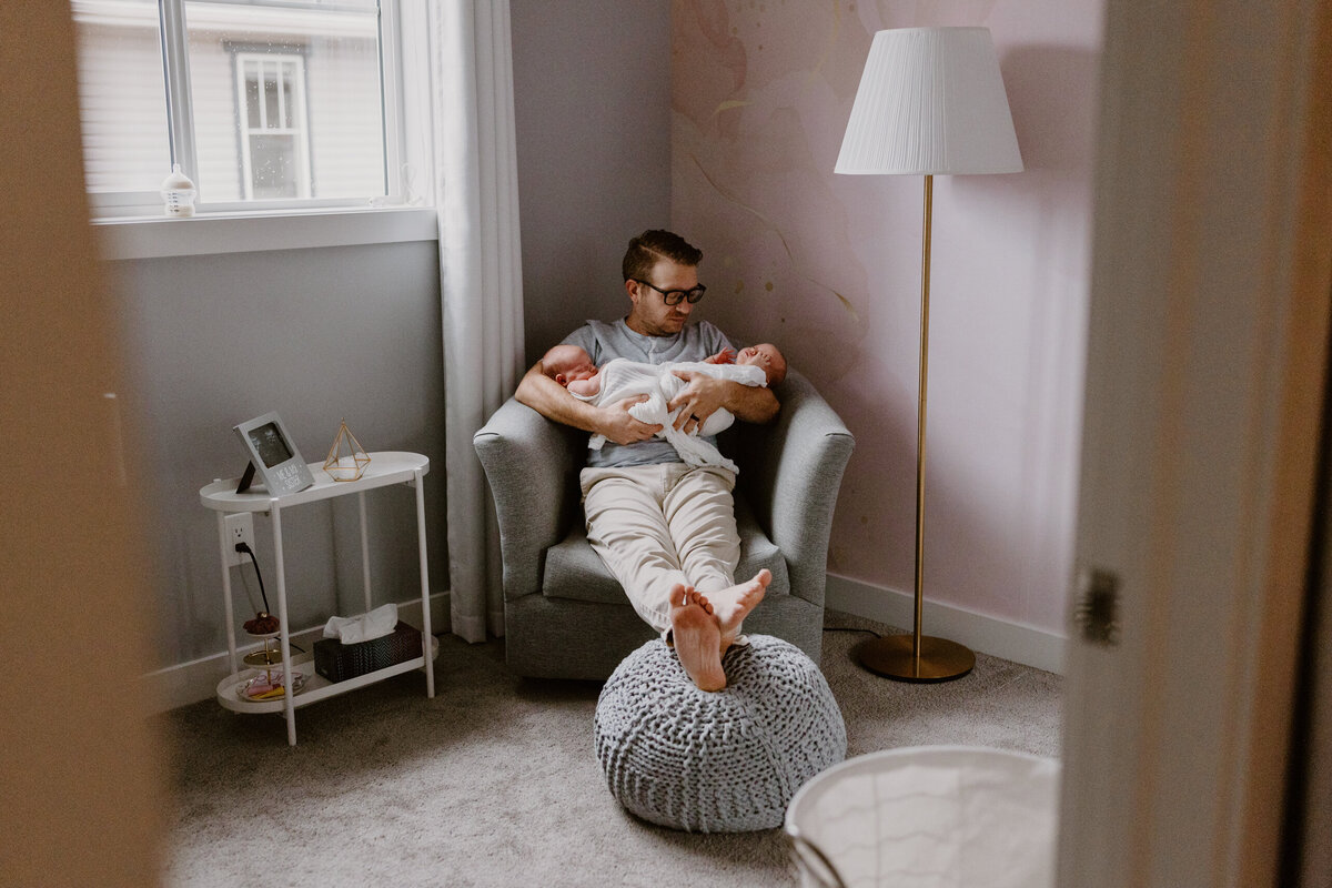 Dad holding newborn twins