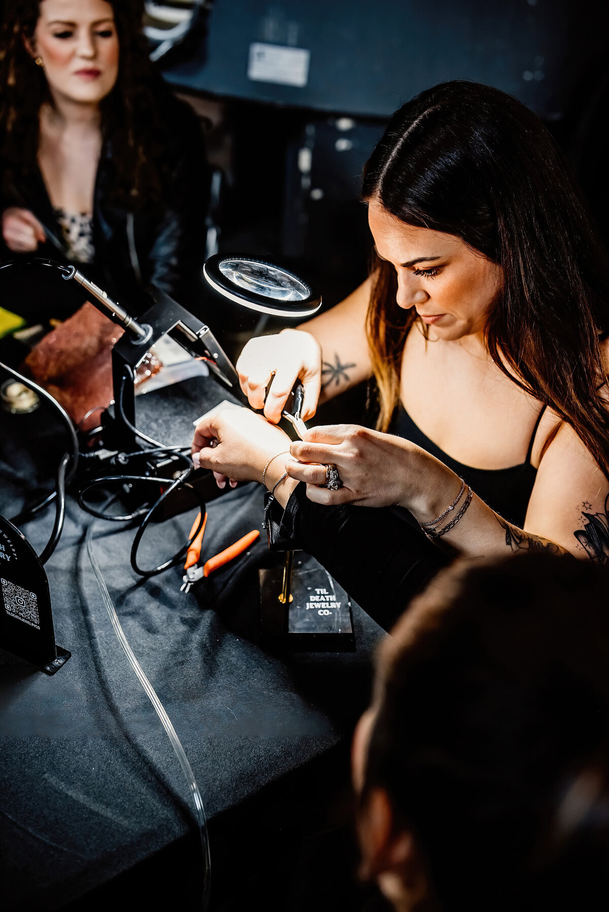 a permanent jewelry artist  fusing a bracelet on a client