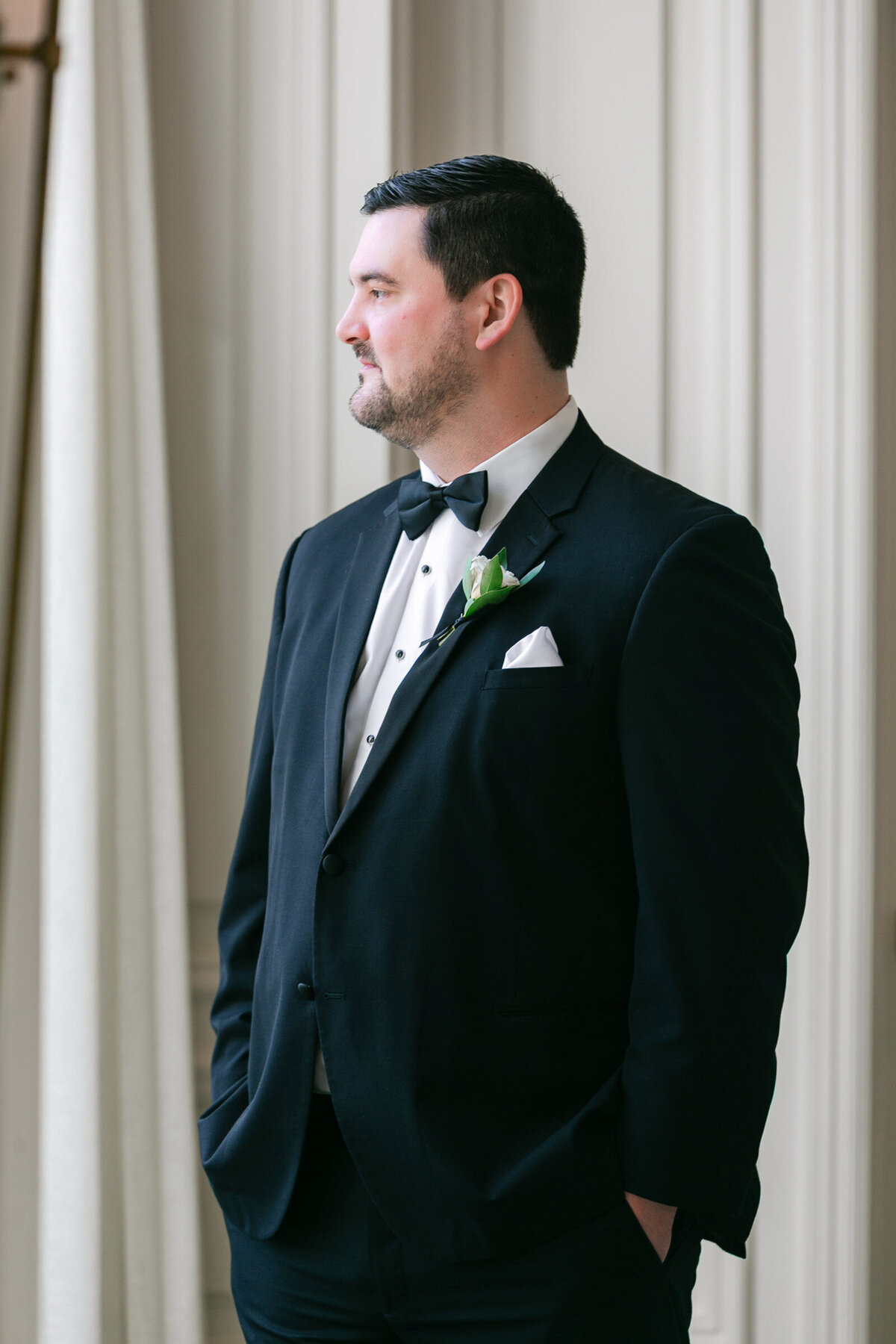 groom standing in the Governor’s Room at The Adolphus in Dallas, waiting for the bride in a classic and elegant wedding portrait.
