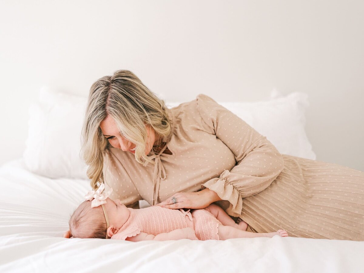  Mother with hand on the belly of her newborn baby girl.