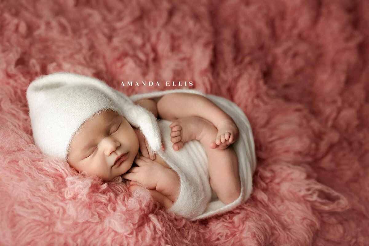 Stunning newborn portrait of baby in pink fuzzy sheet set