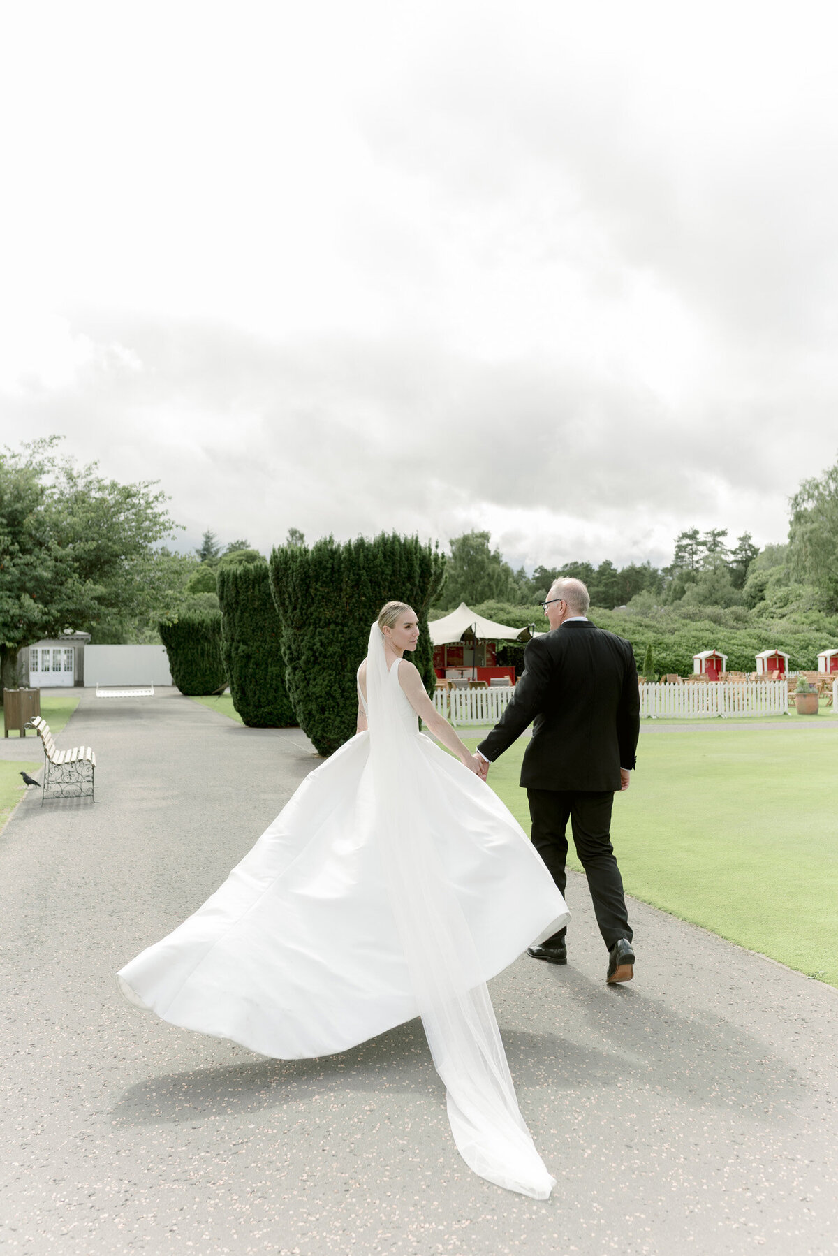 Bride and Groom walk in the ground of the hotel on their Gleneagles wedding day. Image by fine art wedding photographer uk, Jill Cherry Porter.