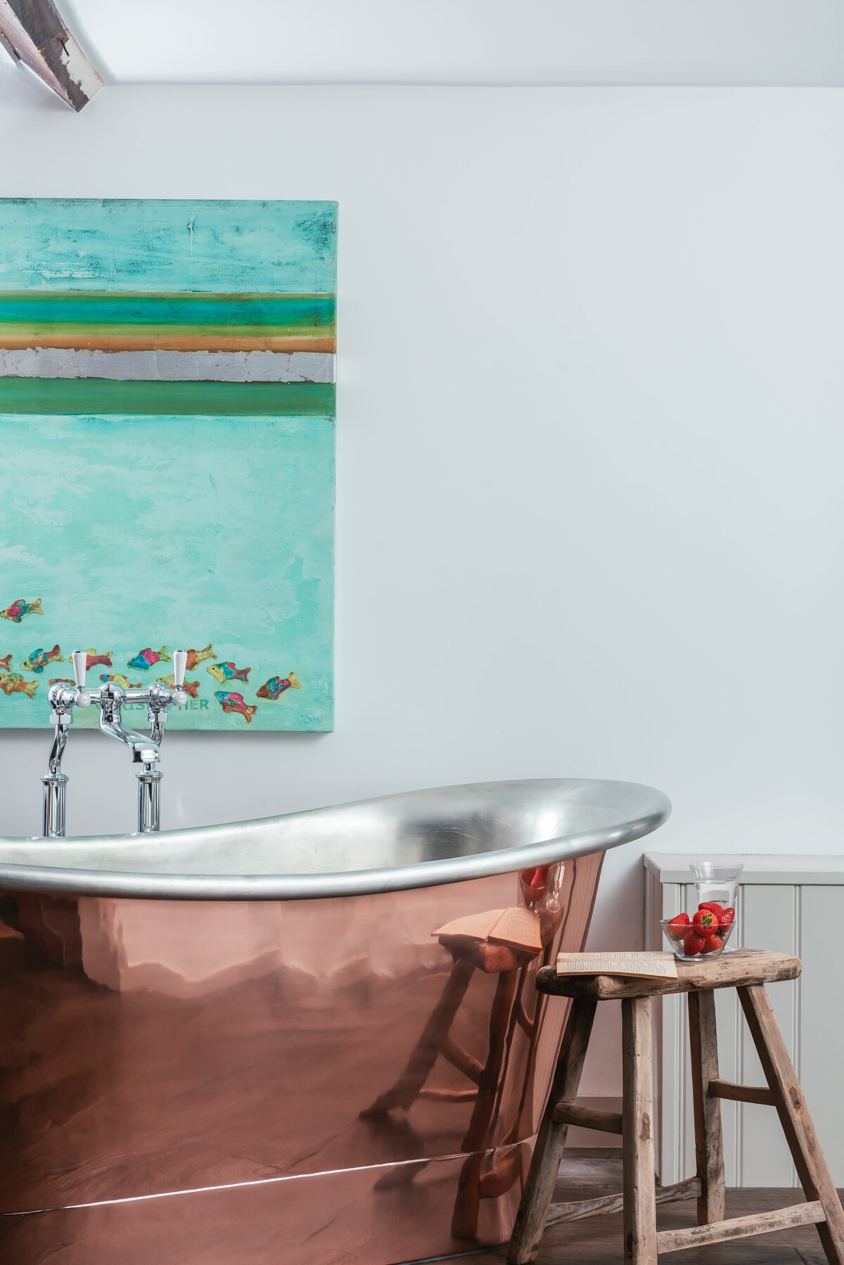 Copper bath with stool beside and painting behind