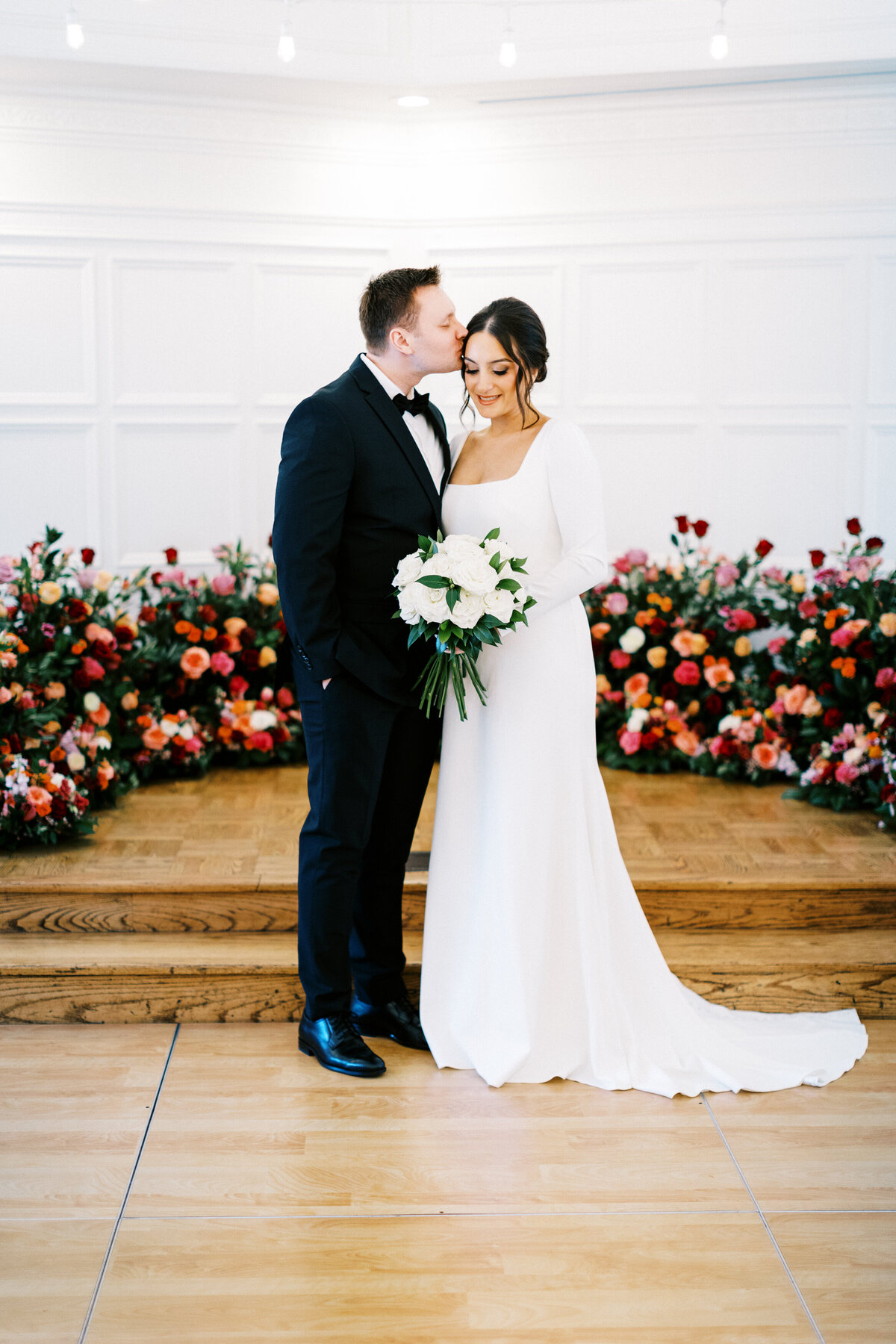 groom is kissing the bride in the head