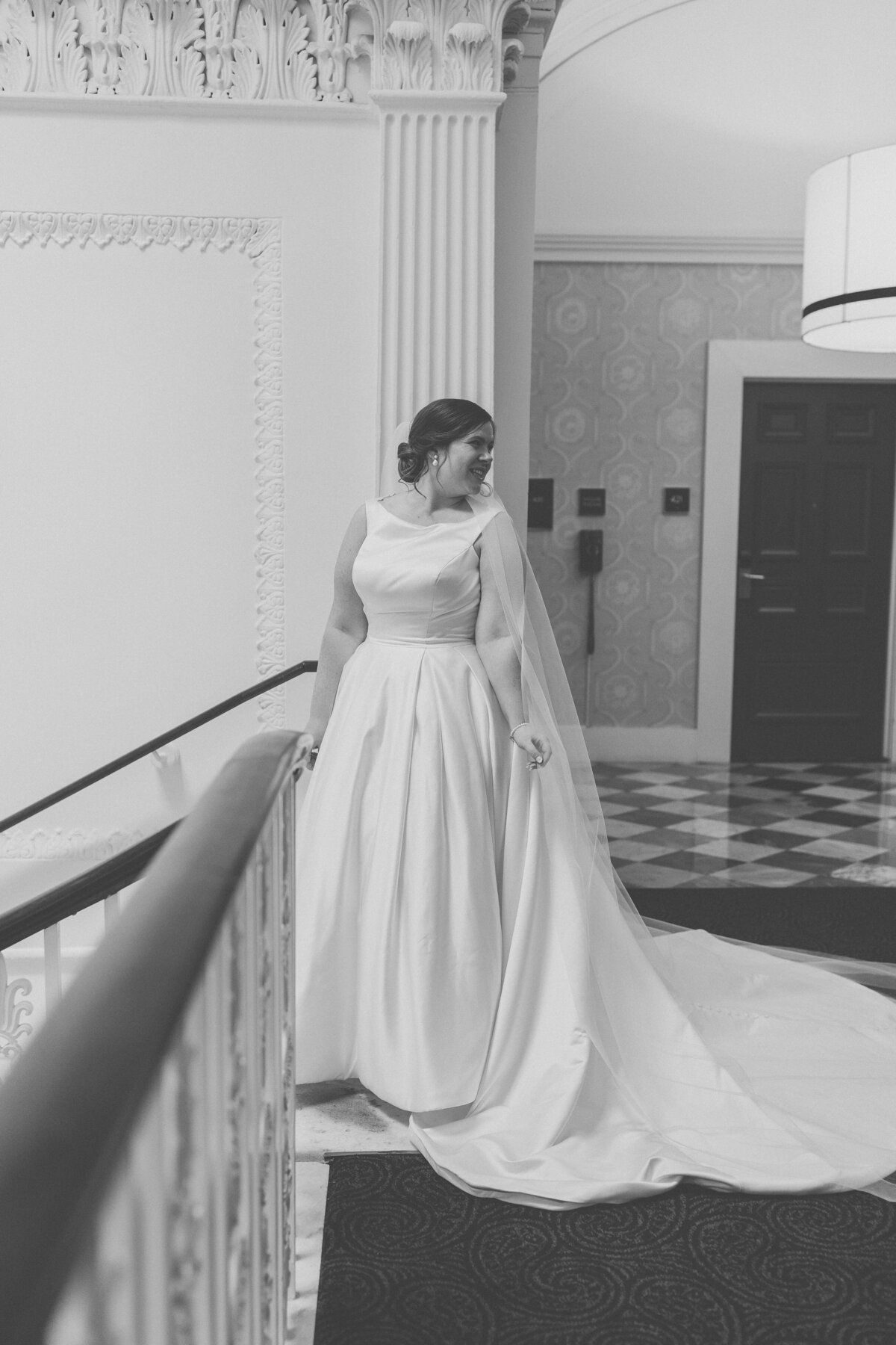 Bride in timeless satin gown posing in marble hall of Hotel Monaco Washington DC.