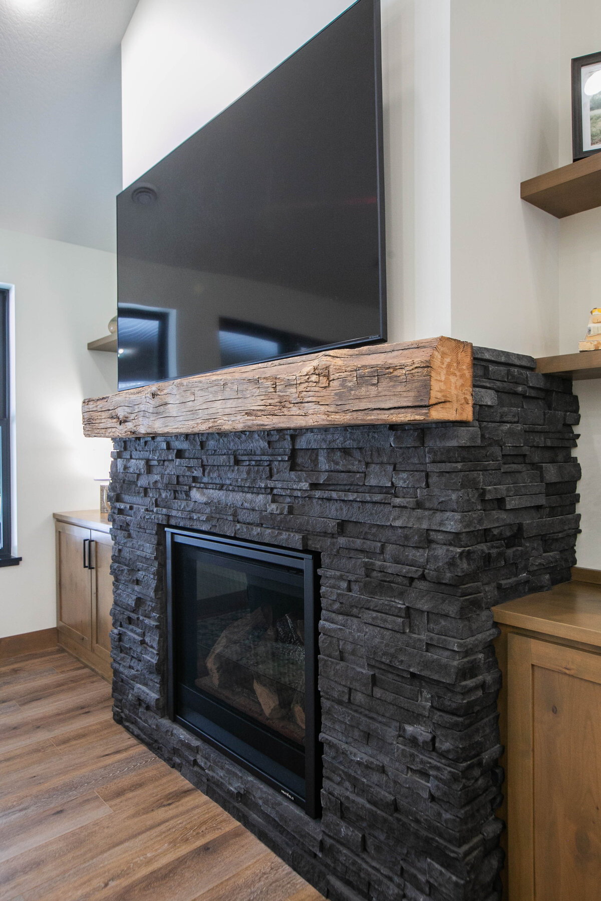 Cozy living room in Elk River custom home with fireplace, built-ins, and large windows