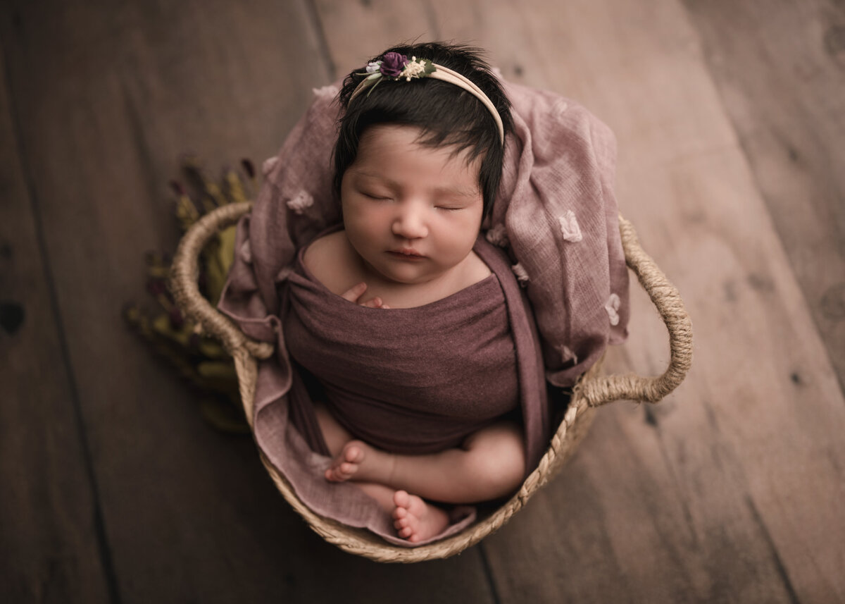 Aerial image of Riverside, CA newborn photoshoot. Baby girl wrapped in plum sleeping. Captured by Best Riverside, CA newborn photographer Bonny Lynn Photography.
