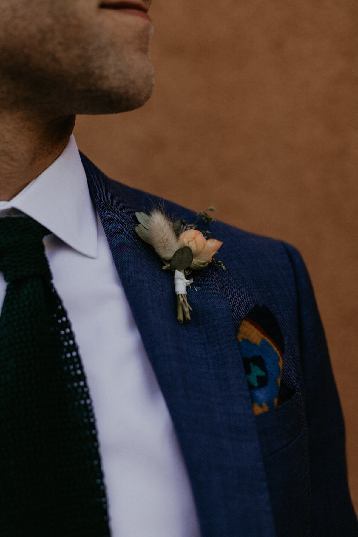 close up of groom boutonniere on his blue suit