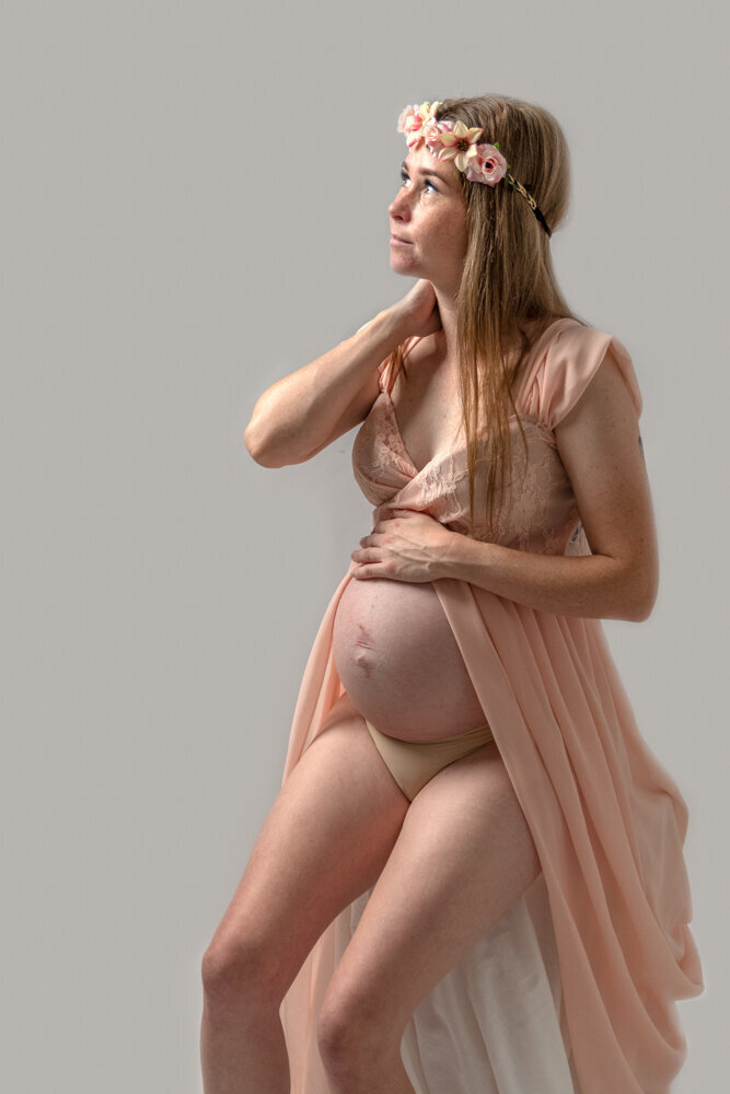 pregnant woman sitting on a stool showing off baby belly - Townsville Maternity Photography by Jamie Simmons