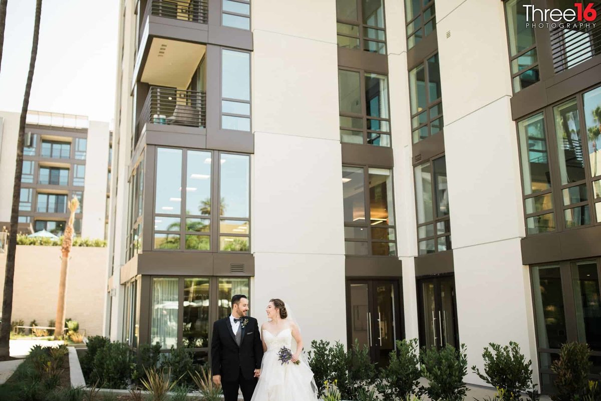 Bride and Groom pose in front of the Avenue of the Arts Hotel in Costa Mesa