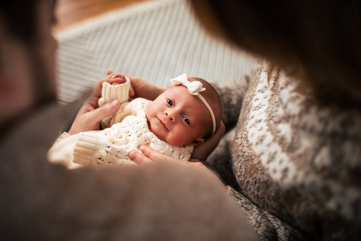 Girl with a cream colored bow stairs into the camera during her family Studio portrait session