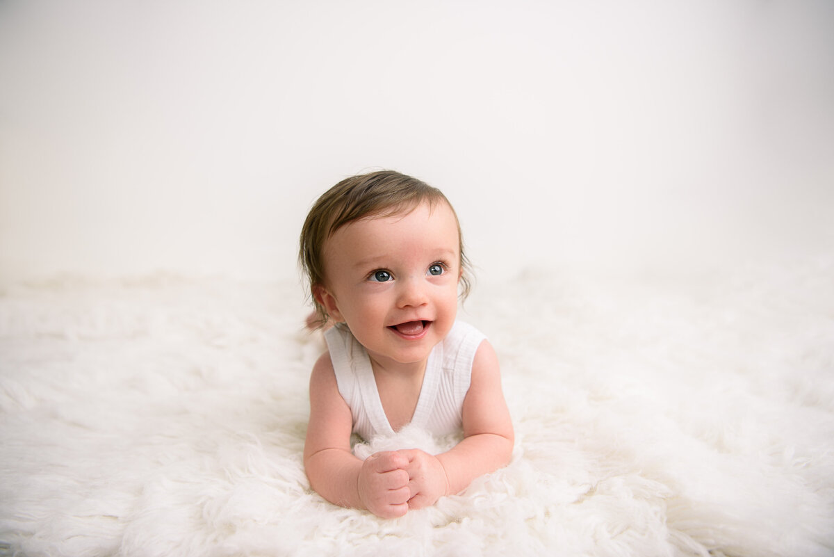 Cute baby laying on blanket for 6 month milestone session