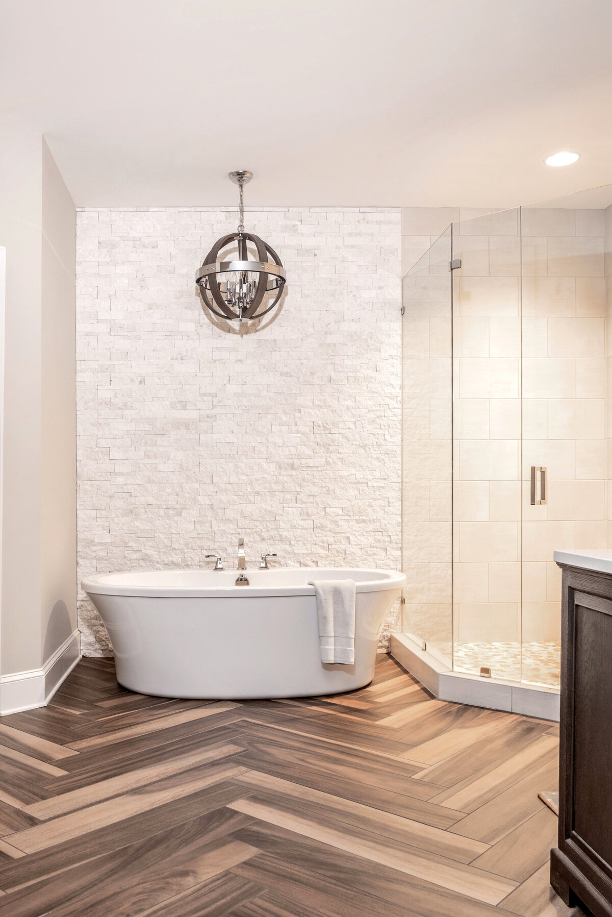 Luxurious bathroom in Lake Norman, NC, with a freestanding bathtub, marble walls, and soft lighting.