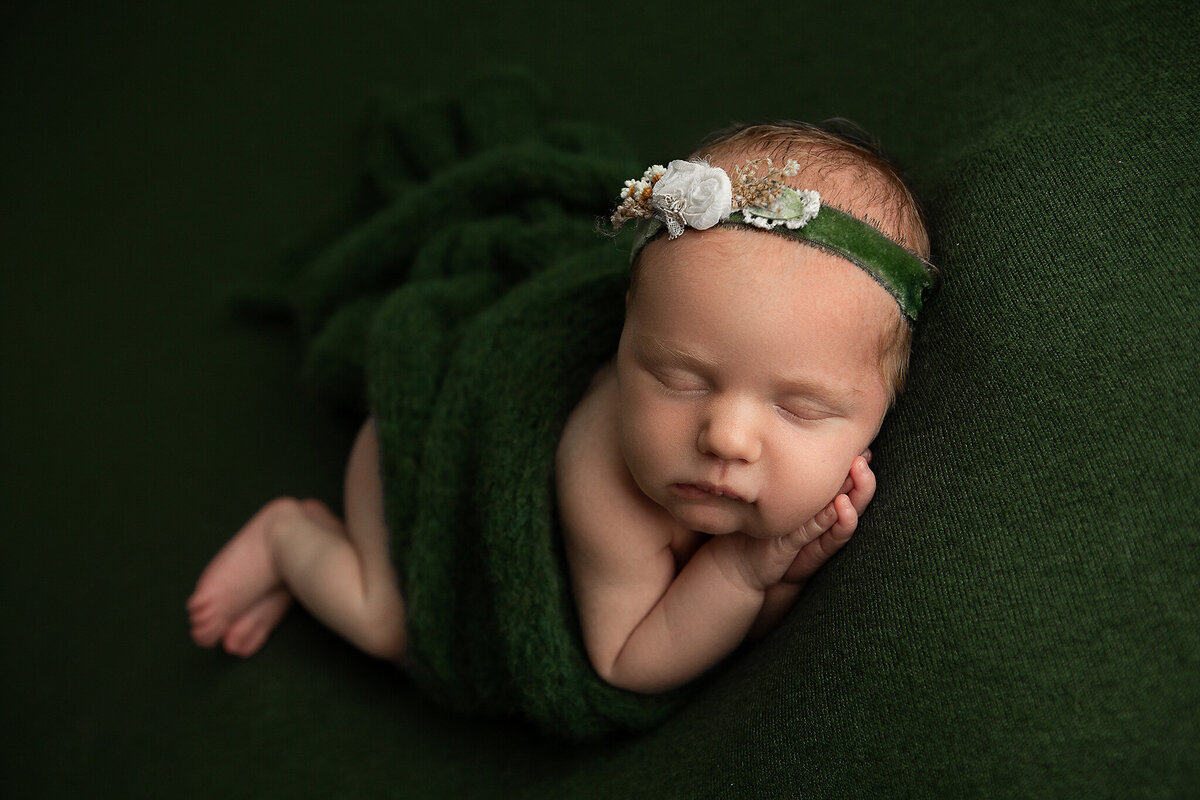 dayton-ohio-newborn-photographer-baby-girl-asleep-with-praying-hands-under-cheek-on-dark-green-blanket