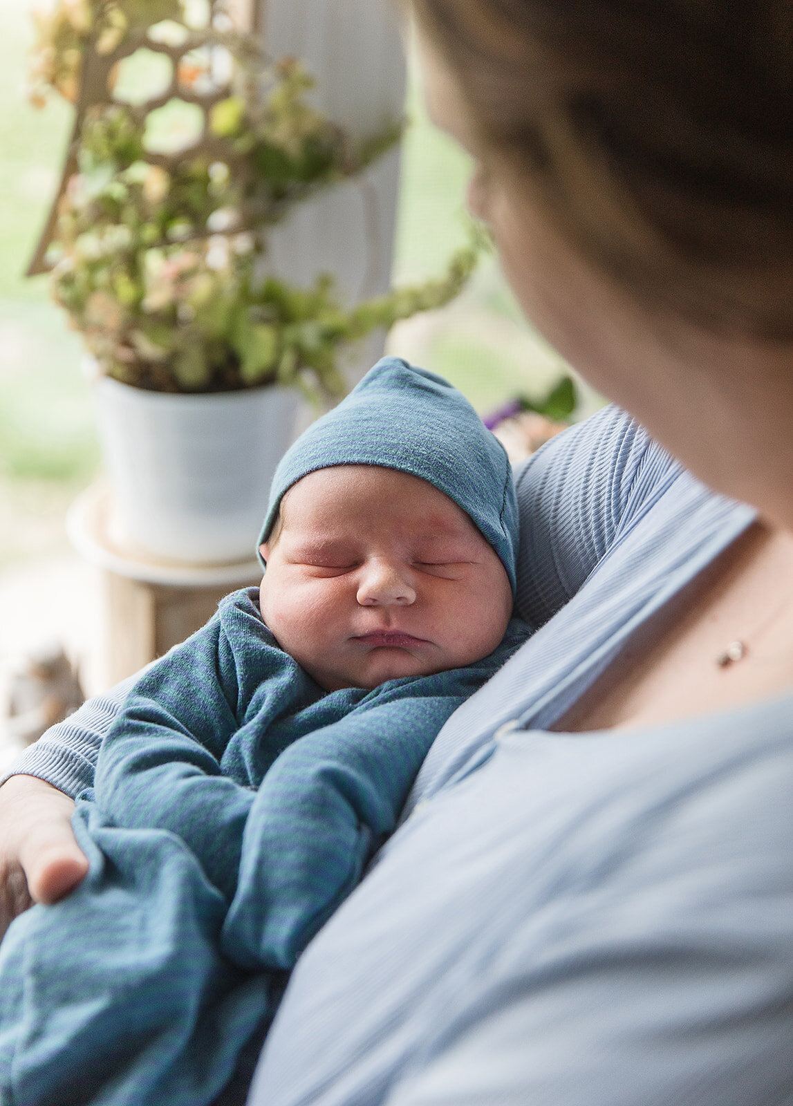 Mom Holds Newborn in Front of Home Window