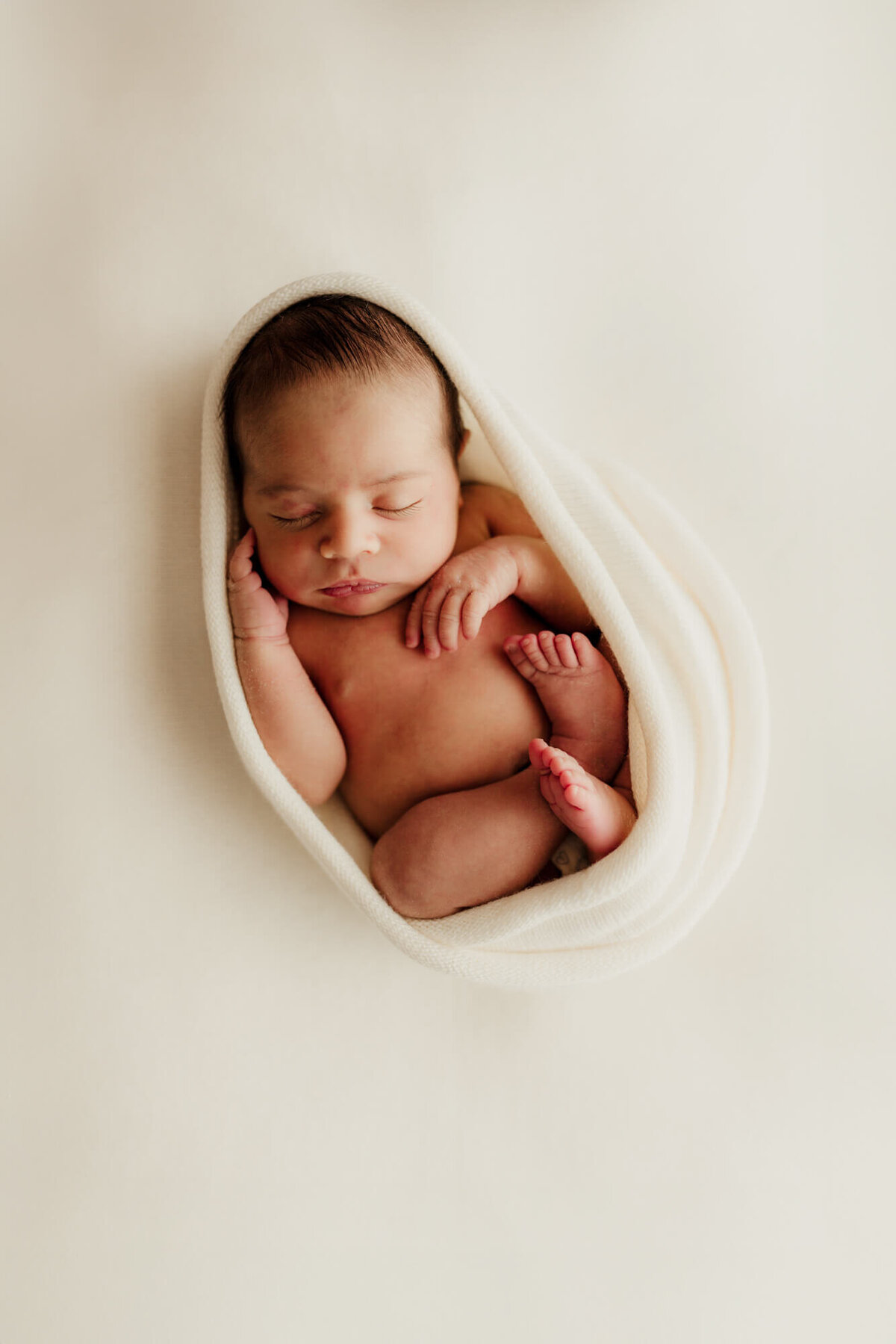 Baby boy wrapped for a womb pose for a studio portrait in OKC.