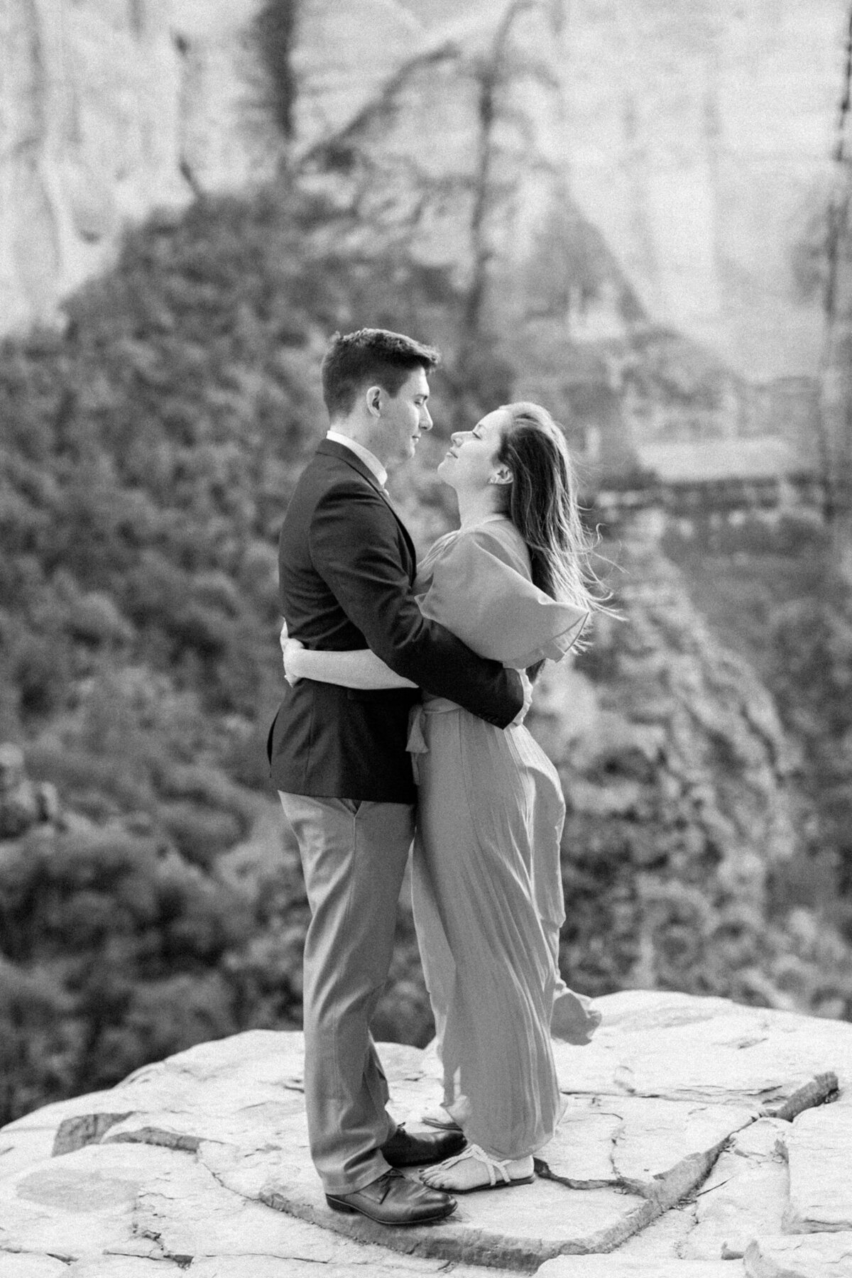 A black and white engagement photo taken at Cathedral Rock in Sedona at sunset.