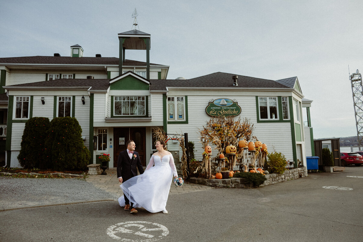newlyweds-walking-in-front-of-la-goeliche-at-ile-dorleans-in-quebec-1