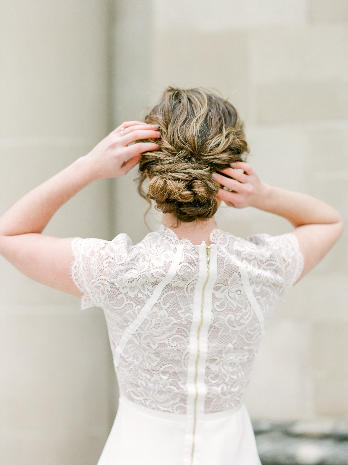 bride in short sleeve lace dress adjusting hair