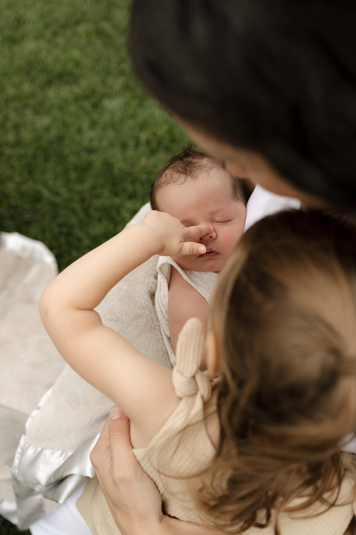big sister touching newborn brothers nose during lifestyle in home newborn session in longmont colorado with alexis adkins photography