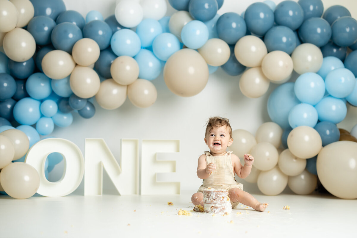 Baby boy smiling during Blue simple themed cake smash session in Canton GA