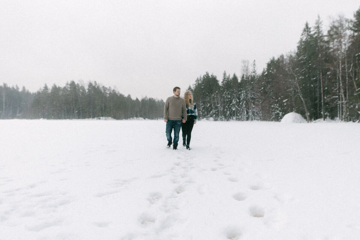 Kihlapari järven jäällä talvisessa kihlakuvauksessa valokuvaaja Hannika Gabrielssonin ottamassa valokuvassa