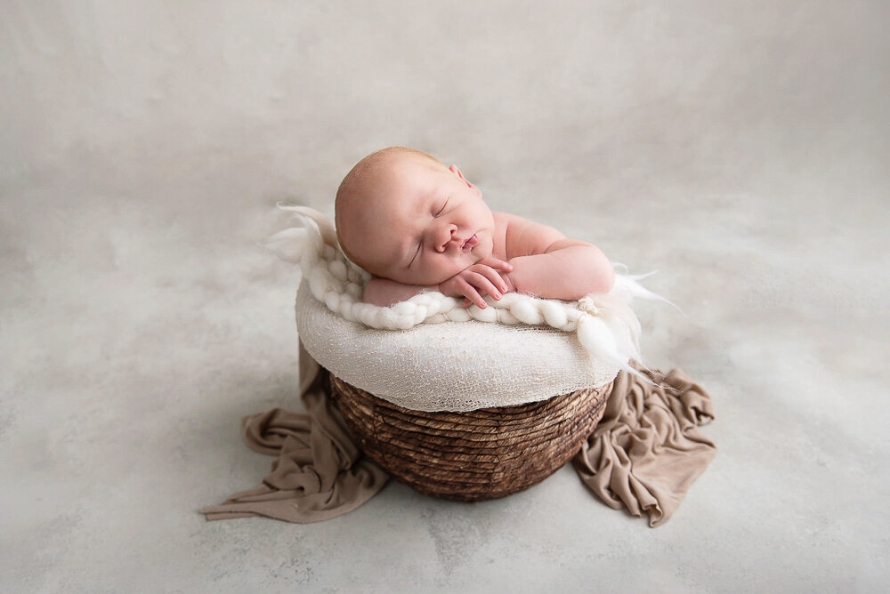 Newborn baby boy in a bucket.