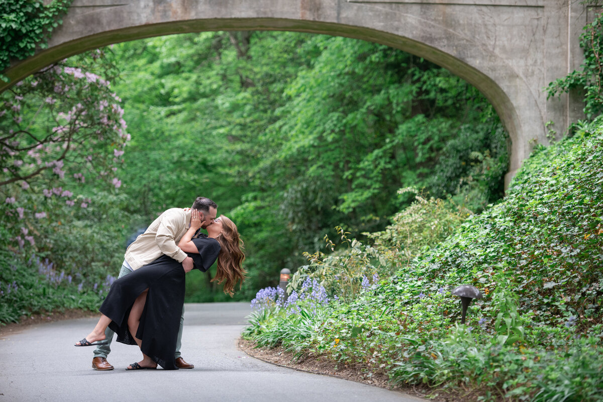 dip_and_kiss_engagement_photo_under_park_bridge_outdoors