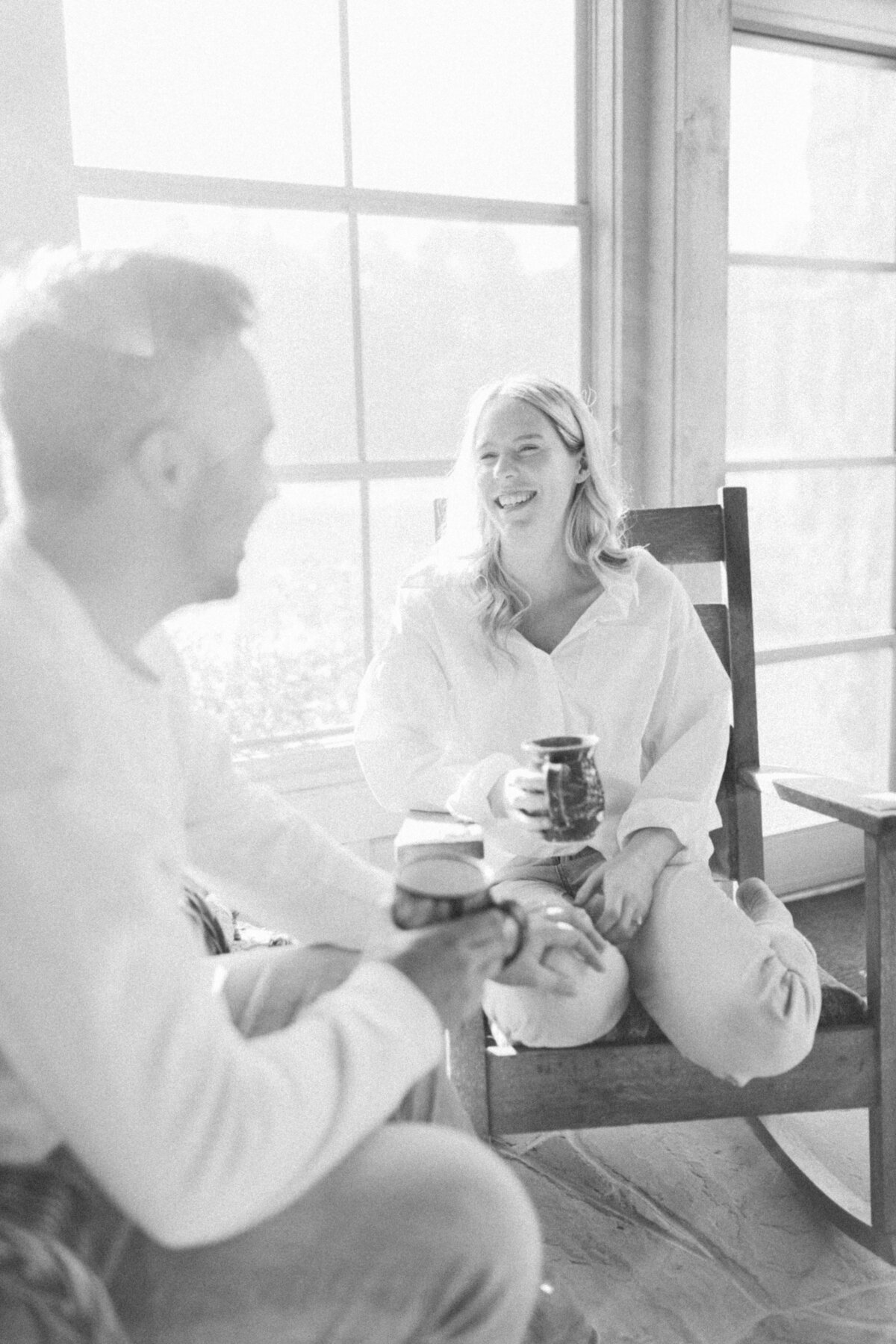 A tranquil sunroom at Elora Mill, with light streaming through the large windows, inviting quiet moments of conversation.