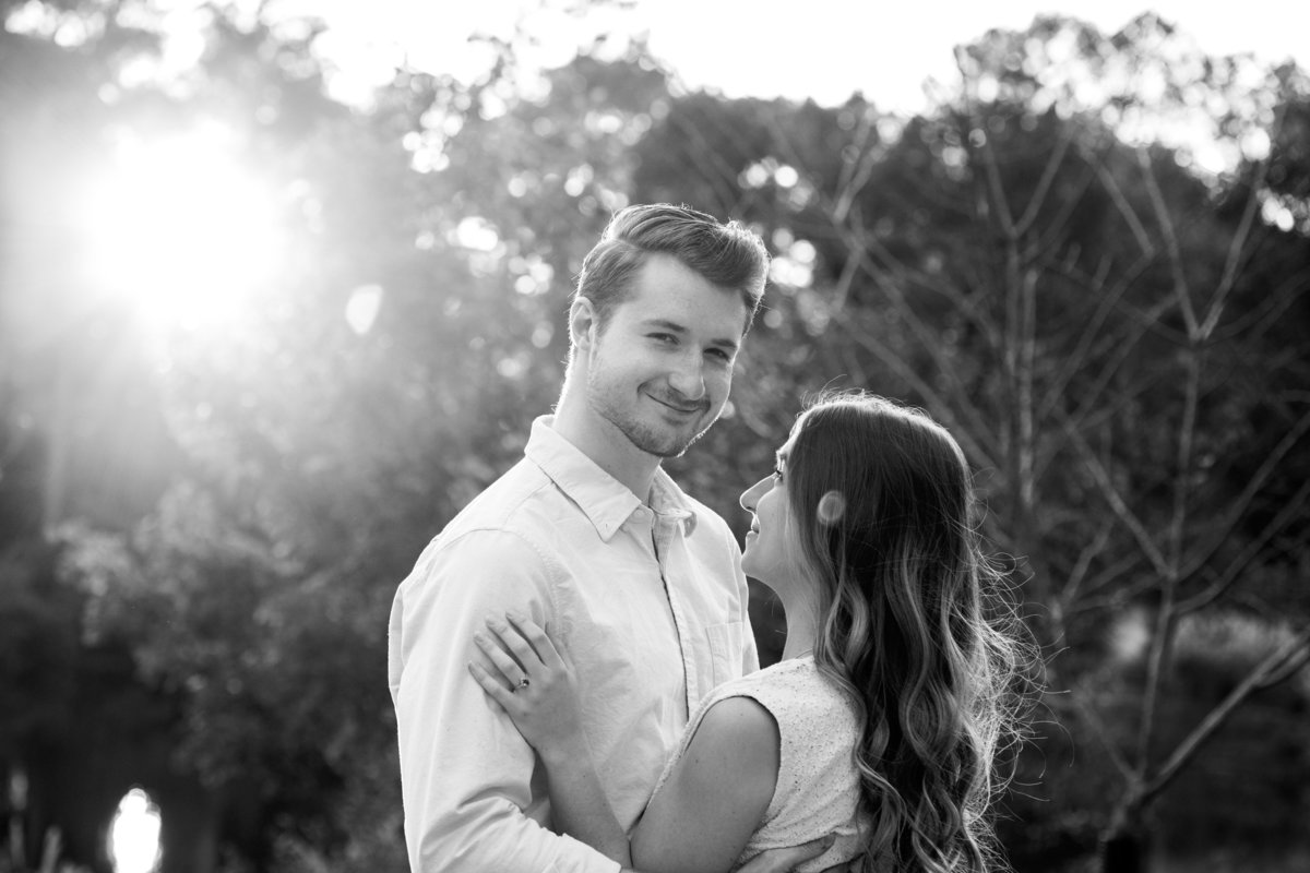Black and white with sun flare of engaged couple