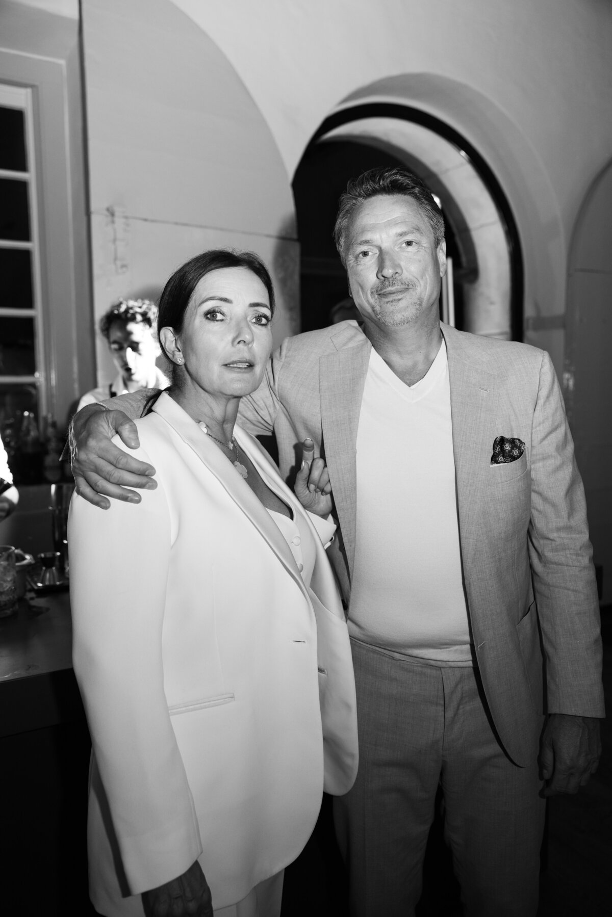 A stylish woman and man pose together in a chic setting during an exclusive event at the Amsterdam Maritime Museum. The black-and-white photo emphasizes the timeless elegance of the moment.