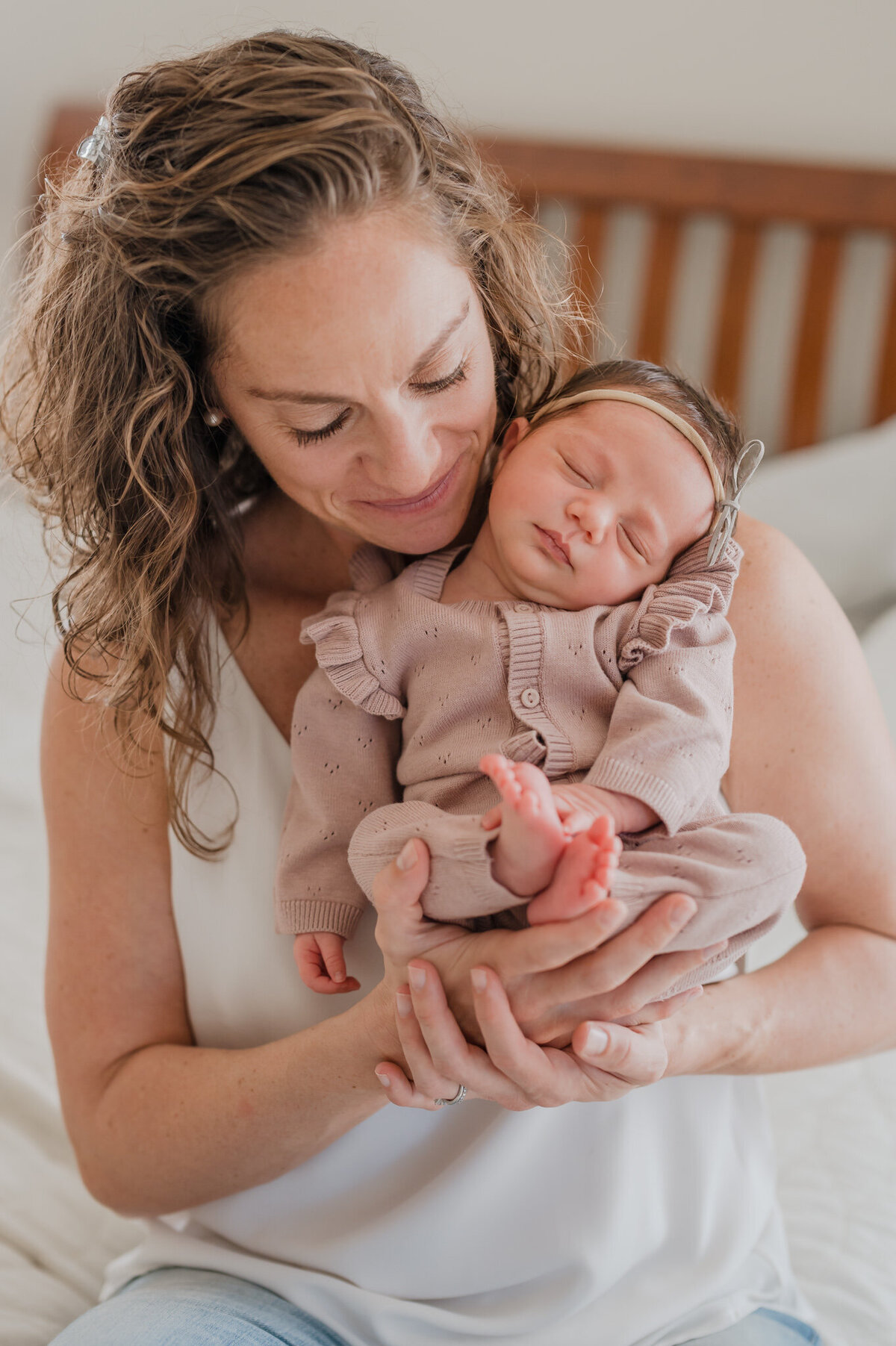 Mom holds baby up and snuggles her close during San Antonio newborn pictures.