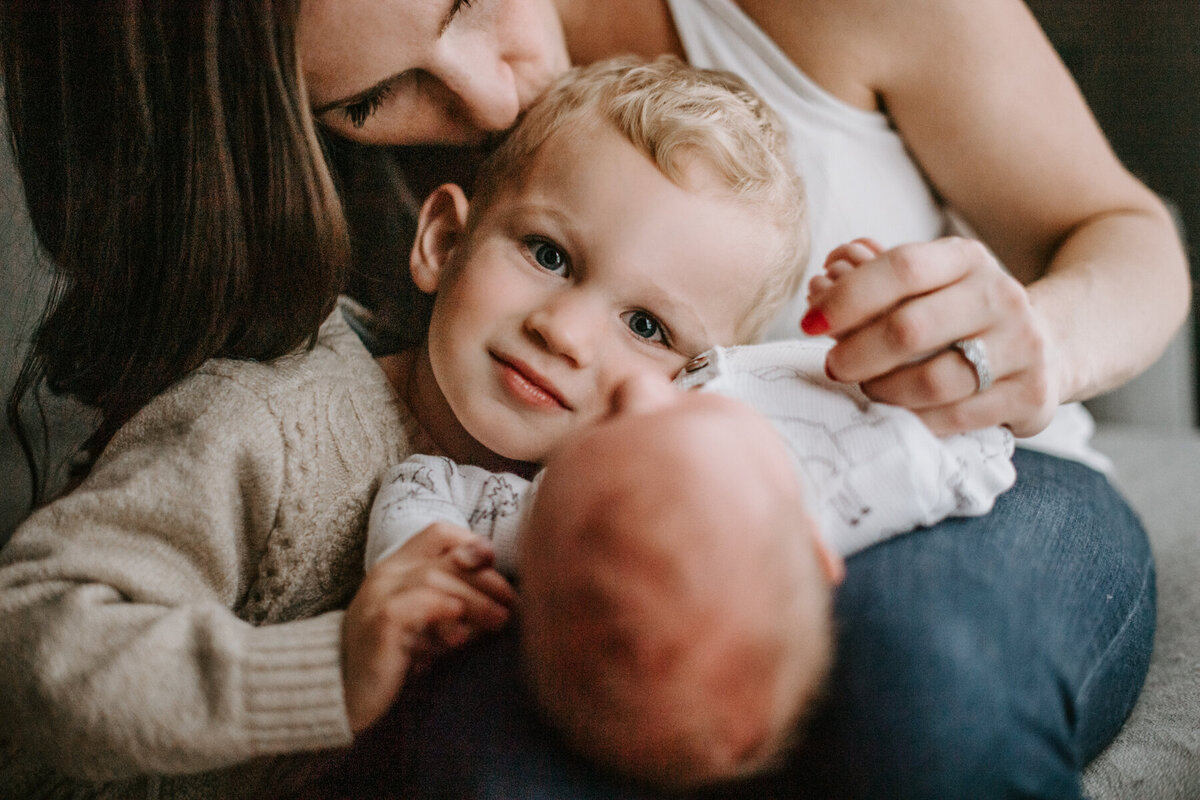 Newborn Photographer, little boy leaning on mother's lap